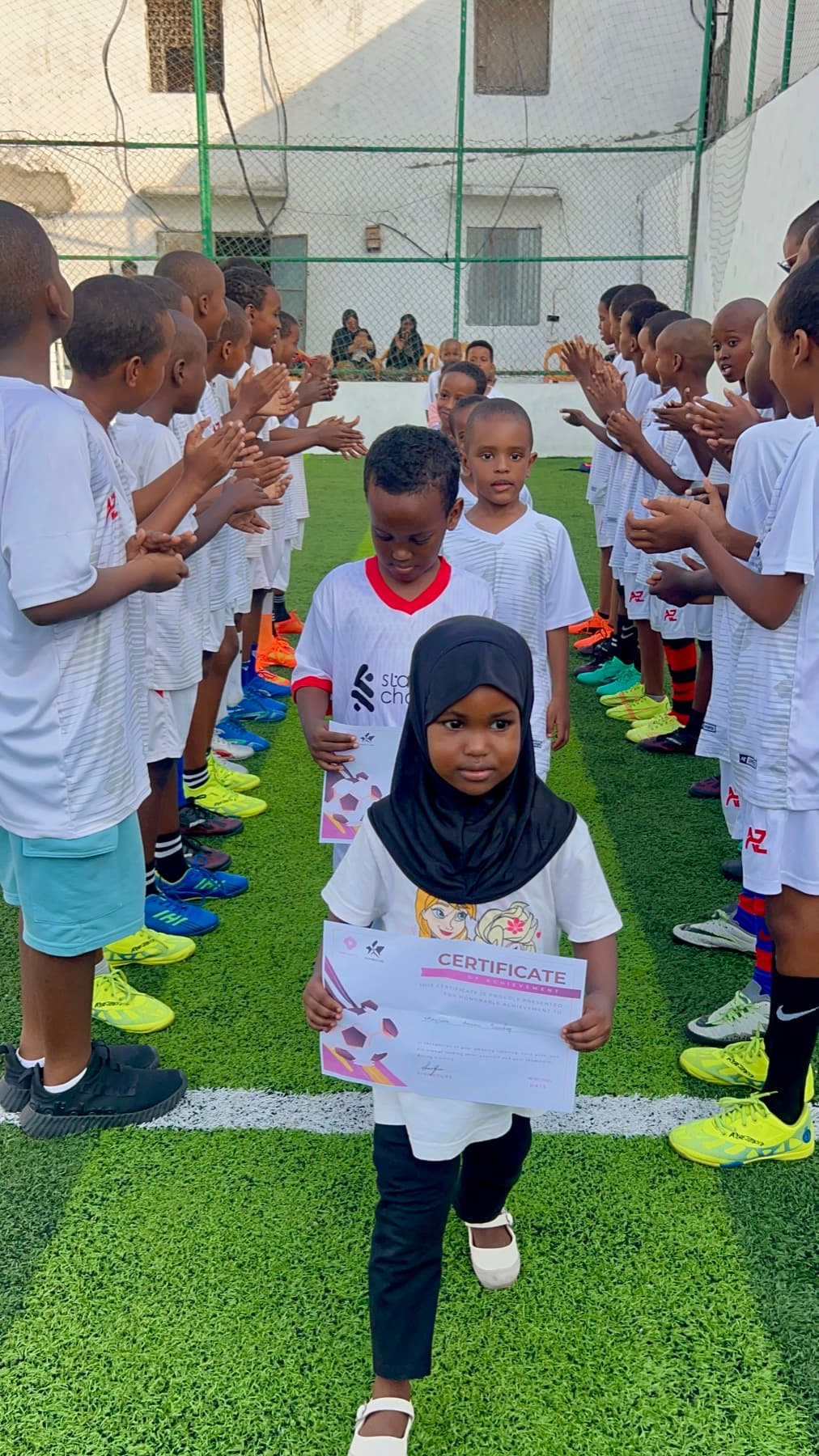 A young girl receiving recognition at a football event