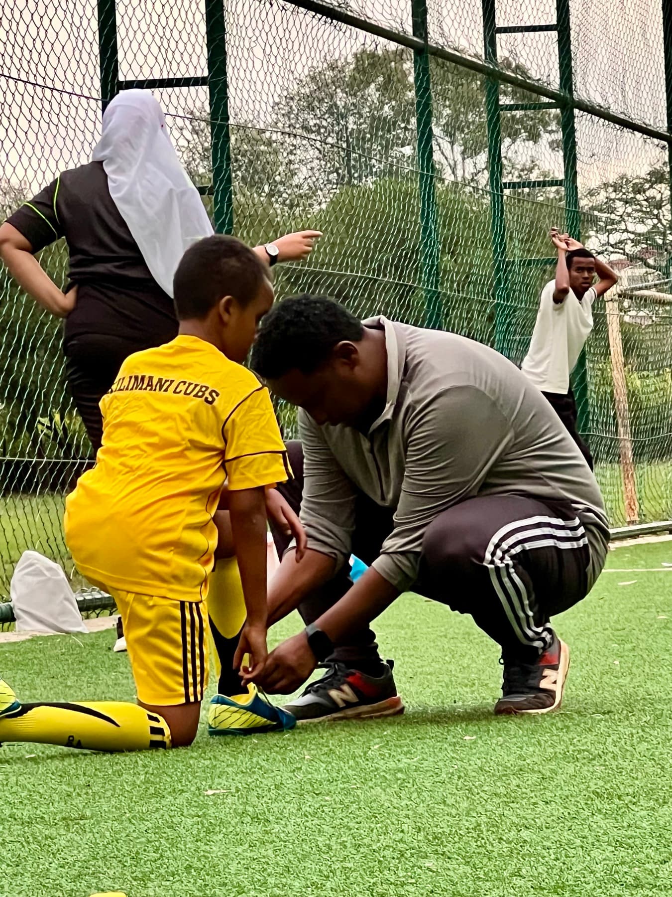 A coach helping a young footballer